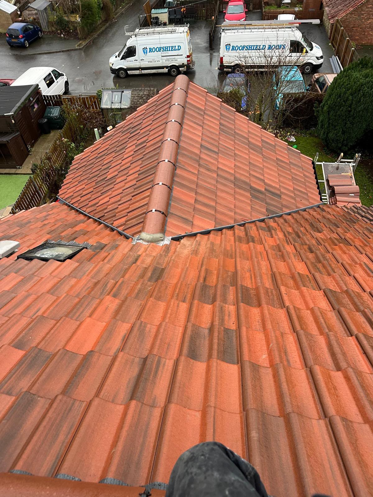 New red tiled hipped roof with an integrated rooflight fitted to code