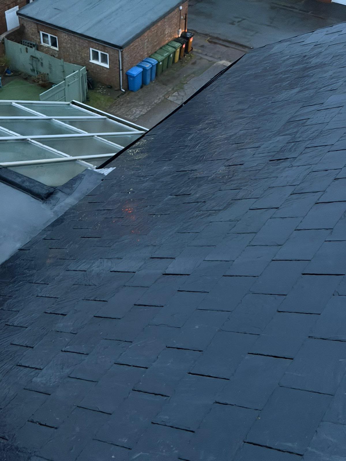 New grey slate pitched roof running into a black EPDM flat roof section
